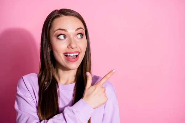 Closeup foto de atraente animado senhora direto dedos olhar lado vazio espaço mostrar novidade banner venda shopping center desgaste casual roxo suéter isolado rosa pastel cor fundo — Fotografia de Stock