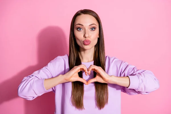 Foto de atraente bonita senhora mãos braços mostrar coração símbolo expressar sentimentos cardíacos romântico data enviar beijos de ar namorado desgaste casual roxo suéter isolado rosa pastel cor fundo — Fotografia de Stock