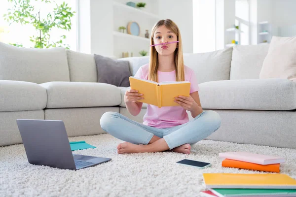 Foto de cuerpo completo de niña loca estudio remoto escribir ensayo copybook necesidad descanso relajarse poner lápiz de la nariz mueca cara sentarse piso alfombra piernas cruzadas dobladas en casa interior — Foto de Stock