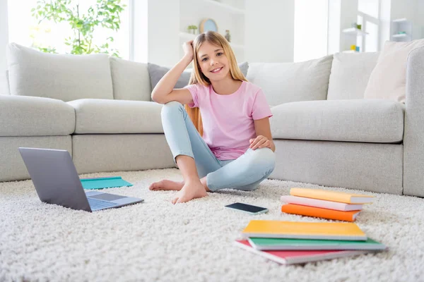 Foto de longitud completa de alumna alegre positivo sentarse alfombra de piso disfrutar de la educación a distancia estudio homeschool en casa apartamento en interiores — Foto de Stock