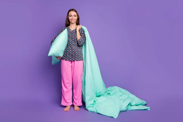 Photo pleine grandeur de fille gaie positive tenir oreiller couverture couette porter pointillé pantalon rose pantalon pyjama isolé sur fond violet couleur pourpre — Photo