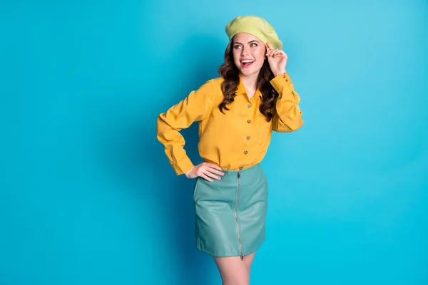 Foto de menina encantadora sincero desfrutar de férias primavera olhar copyspace toque boina quer atrair cara desgaste bom olhar roupas isoladas sobre fundo de cor azul — Fotografia de Stock