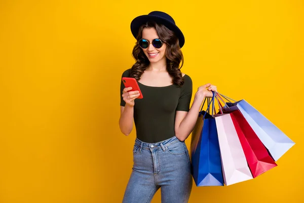 Retrato de ella ella agradable atractiva encantadora de moda alegre chica de pelo ondulado que lleva cosas nuevas utilizando la célula que ordena la entrega a domicilio aislado en brillante brillo vivo vibrante color amarillo fondo — Foto de Stock