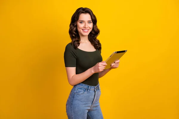 Profile side view portrait of her she nice attractive lovely pretty cheerful cheery wavy-haired girl holding in hands ebook reading isolated on bright vivid shine vibrant yellow color background