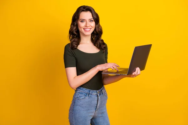 Retrato dela ela agradável atraente adorável confiante alegre alegre menina de cabelos ondulados segurando na mão laptop trabalhando remotamente a tempo parcial isolado no brilhante brilho vívido vibrante cor amarela fundo — Fotografia de Stock