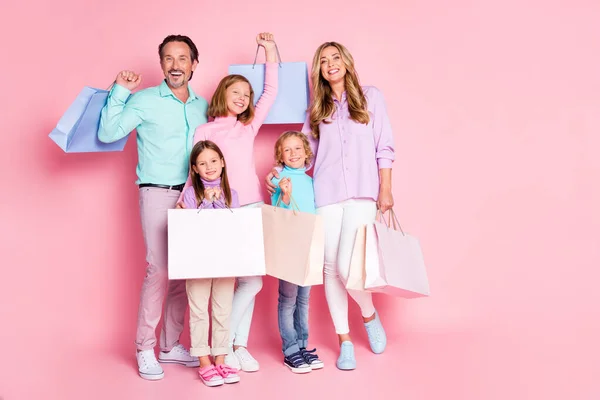 Πλήρης φωτογραφία του σώματος των θετικών ανθρώπων ψώνια πελάτες εμπορικό κέντρο ευτυχισμένη οικογένεια αγοράσουν μαμά μπαμπάς μαμά μπαμπάς μπαμπάς τρία μικρά παιδιά κρατούν τσάντες απομονωμένες σε παστέλ χρώμα φόντο — Φωτογραφία Αρχείου