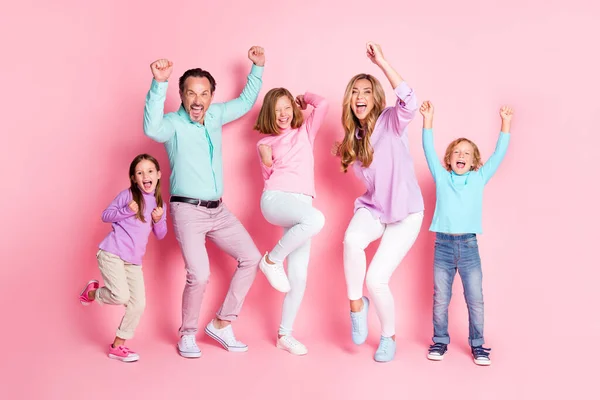 Pleine longueur photo extatique papa maman et trois petits enfants de préadolescence profiter se réjouir gagner jeu de famille lever les poings crier porter des vêtements de style décontracté isolé fond de couleur pastel — Photo