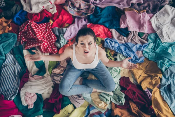 High angle above view photo of stressed helpless lady stay home spring cleaning household sit many clothes stack floor pick select outfit nothing to wear concept all stuff dirty indoors — Stock Photo, Image