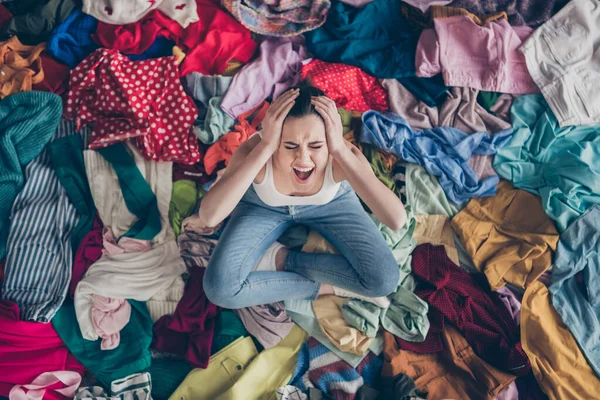 Help. High angle above view photo of stressed yelling lady stay home spring cleaning household sit many clothes stack floor pick select look outfit nothing to wear hands on head indoors — Stock Photo, Image