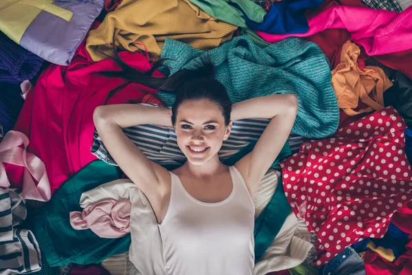 Alto ángulo arriba ver la foto de la señora bastante alegre quedarse en casa cuarentena limpieza de primavera hogar acostado mucha ropa pila piso preparado desordenado cosas sucias lavadora en el interior —  Fotos de Stock