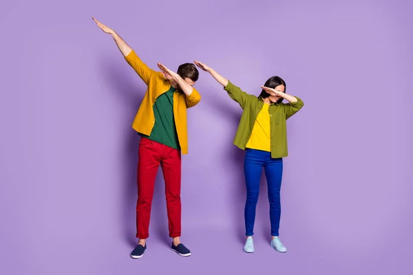 全身像女同学同学两个人跳舞现代奇形怪状的青春舞步轻柔的动作穿休闲型的绿色衬衫长裤鞋孤立的紫色底色 — 图库照片