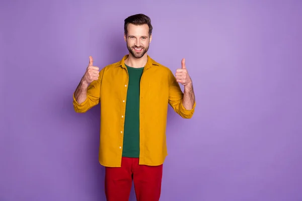 Zdjęcie atrakcyjny przystojny facet podnieść kciuk palce w górę overjoyed otwarte usta wyrażając zgodę nosić casual żółty koszula czerwone spodnie odizolowane fioletowy kolor tła — Zdjęcie stockowe
