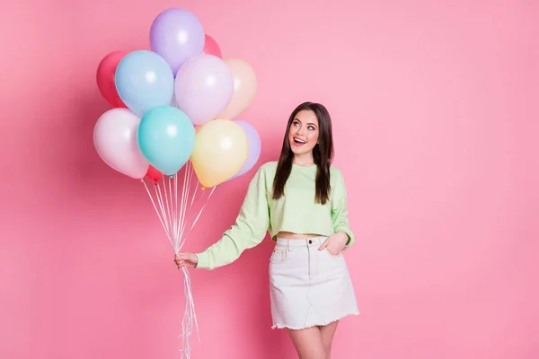 Foto de alegre dama encantadora organizar fiesta de cumpleaños sorpresa mejor amigo celebrar muchos globos de aire llevar casual verde de la cosecha pantalones vaqueros mini falda aislado rosa pastel color fondo — Foto de Stock