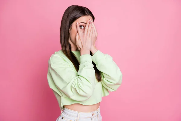 Photo of attractive funny lady closing eyes arms peeking glance wanna know secret curious person wear casual green crop sweatshirt pullover isolated pink pastel color background — Stock Photo, Image