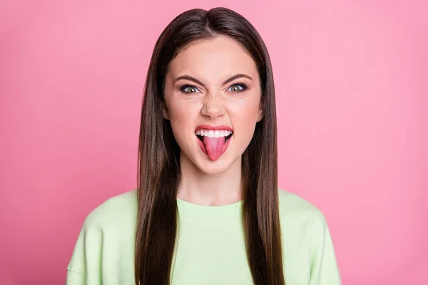 Closeup foto de engraçado atraente senhora longo penteado menina pau língua boca brincalhão humor provocando namorado rude pessoa usar casual verde sweatshirt pulôver isolado cor rosa fundo — Fotografia de Stock