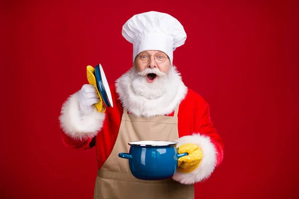 Zdjęcie zdumiony Mikołaj otwarty rondel garnek okładka x-mas tradycja obiad gotowanie nosić szef kuchni czapka czerwony kostium fartuch odizolowany jasny połysk kolor tło — Zdjęcie stockowe