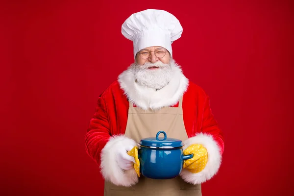 Foto von Märchen stilvolle Weihnachtsmann halten Topf X-mas Tradition Mahlzeit tragen Kochmütze rot Kostümschürze isoliert über hellem Glanz Farbe Hintergrund — Stockfoto
