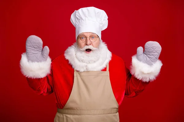 Foto von erstaunt Weihnachtsmann tragen Topfhalter Kochmütze Schürze rot Kostüm Weihnachtsbacken Kochen isoliert über hellem Glanz Farbe Hintergrund — Stockfoto