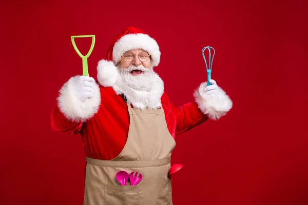 Photo of crazy modern funky Santa Claus szef kuchni trzymać x-mas gotowania naczynia kuchenne nosić czerwony kostium fartuch izolowany na jasny połysk kolor tła — Zdjęcie stockowe