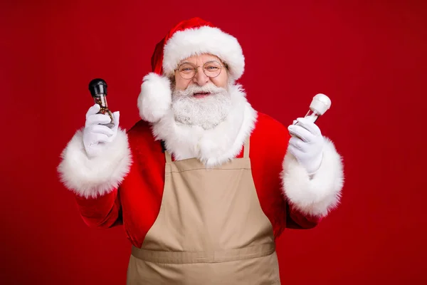 Zdjęcie szalony nowoczesny Święty Mikołaj trzymać sól pieprz x-mas posiłek gotowanie nosić fartuch czapka czerwona kostium izolowane na jasnym tle kolor połysk — Zdjęcie stockowe