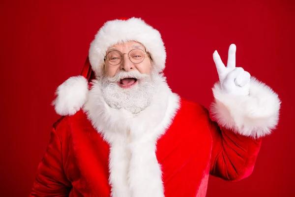 Portret szalony stylowy Święty Mikołaj cieszyć X-mas Boże Narodzenie zrobić v-sign nosić czerwony kostium czapka białe rękawiczki izolowane na jasny połysk kolor tła — Zdjęcie stockowe