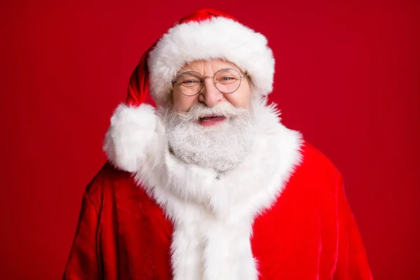 Close up photo of positive cheerful santa claus look in camera wear red costume hat isolated over shine vivid color background — Stock Photo, Image