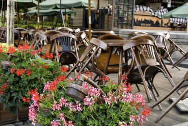 Ahşap sandalyeli kapalı kafe restoranı, Lviv, Ukrayna 'daki masaların üzerine yığılmış..