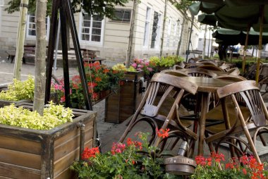 Ahşap sandalyeli kapalı kafe restoranı, Lviv, Ukrayna 'daki masaların üzerine yığılmış..