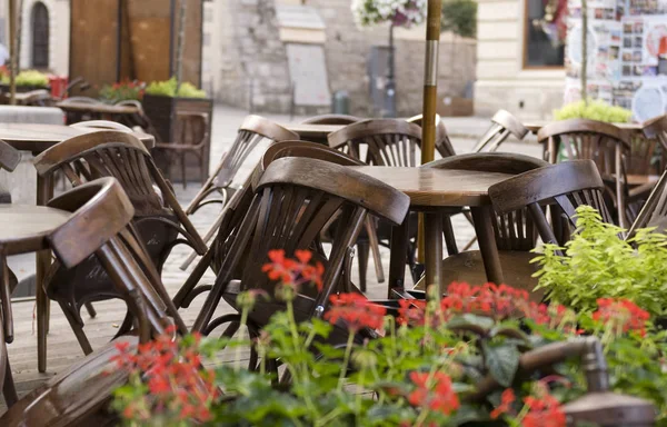 Ahşap sandalyeli kapalı kafe restoranı, Lviv, Ukrayna 'daki masaların üzerine yığılmış..