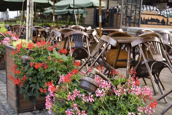 Ahşap sandalyeli kapalı kafe restoranı, Lviv, Ukrayna 'daki masaların üzerine yığılmış..
