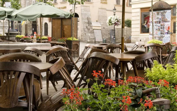 Ahşap sandalyeli kapalı kafe restoranı, Lviv, Ukrayna 'daki masaların üzerine yığılmış..