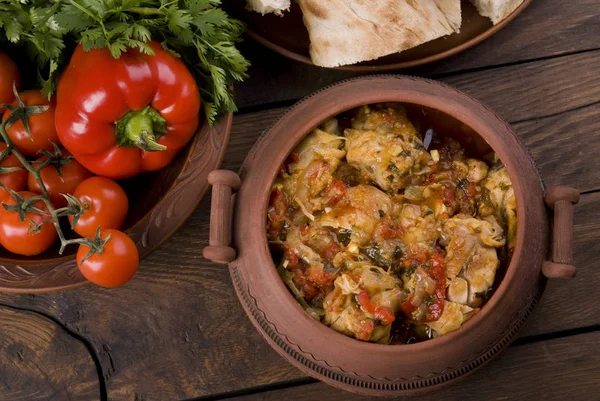 Chakhokhbili - Georgian traditional food. The dishes of Georgia,  chicken with tomatoes and herbs on a wooden background