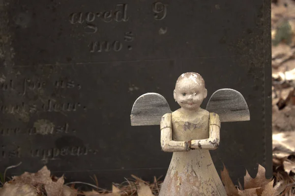 Velho anjo brinquedo no túmulo de uma criança — Fotografia de Stock