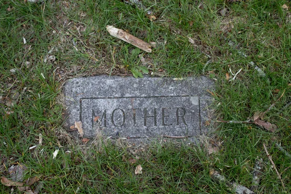 Velha lápide com a mãe sobre ele . — Fotografia de Stock