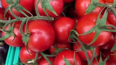 Fresh red tomatoes stacked together on display in grocery market