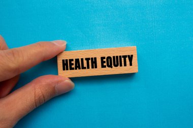 Health Equity message written on wooden block on blue background. Conceptual Health Equity symbol. Copy space.