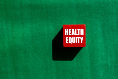 Sağlık Sermayesi mesajı yeşil arka planda kırmızı tahta küpte yazılmış. Kavramsal Sağlık Sermayesi sembolü. Boşluğu kopyala.