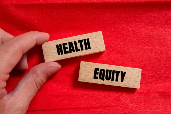 Health Equity message written on wooden blocks on red background. Conceptual Health Equity symbol. Copy space.