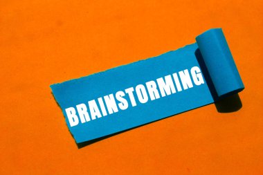 Yırtık kağıt arkaplanına yazılan beyin fırtınası mesajı. Kavramsal Beyin Fırtınası sembolü. Boşluğu kopyala.