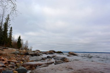 Bulutlu gün gölde kayalarla