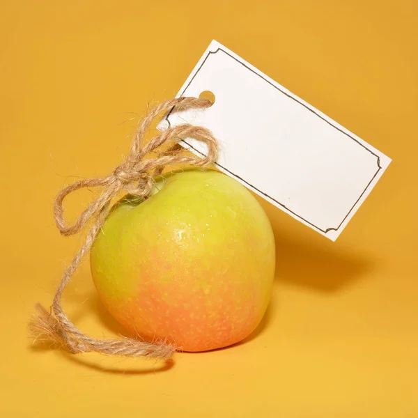 Whole Ripe Apple Empty White Sign Rope Bright Yellow Background — Stock Photo, Image