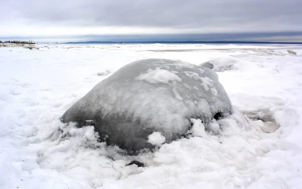 凍った湖の岸に氷で覆われた大きな石 — ストック写真