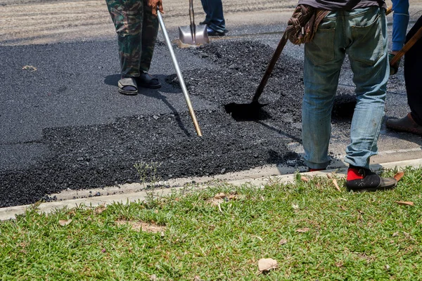 Road Street onarım çalışmaları sırasında kaldırım makinesindeki işçiler