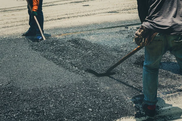 道路補修工事中のアスファルト舗装機械の労働者 — ストック写真