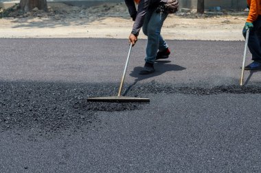 Road Street onarım çalışmaları sırasında kaldırım makinesindeki işçiler