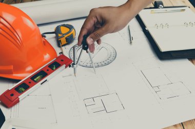 Bir mimar veya mühendis planı üzerinde çalışan, bir mimar veya mühendis plan üzerinde bir bölücü ölçer kullanır., mimari kavram