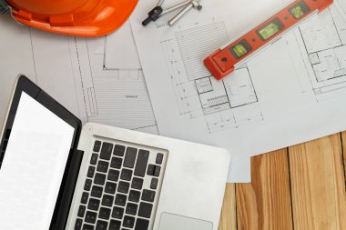 Plan üzerinde kask ve dizüstü bilgisayar ile ölçüm aracı, mimari kavram