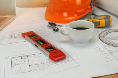 Plan üzerinde kask ve kahve ile ölçüm aracı, mimari kavram