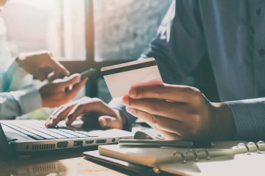 İşadamı kredi kartı tutuyor ve dizüstü bilgisayar kullanıyor. Online alışveriş yaparken ödeme yapma. E-ticaret ve modern teknoloji konsepti