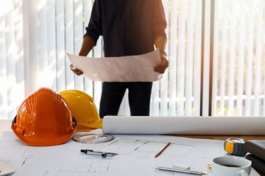 Bir ofiste çalışan mimar. Ofiste plan tutan mühendis, mimari konsept